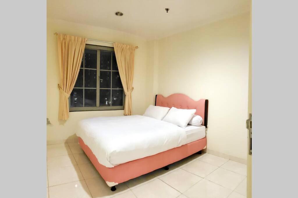 Schlafzimmer mit einem Bett und einem Fenster in der Unterkunft SUPERBLOCK 3 BEDROOM 103sqm AT MALL in Jakarta