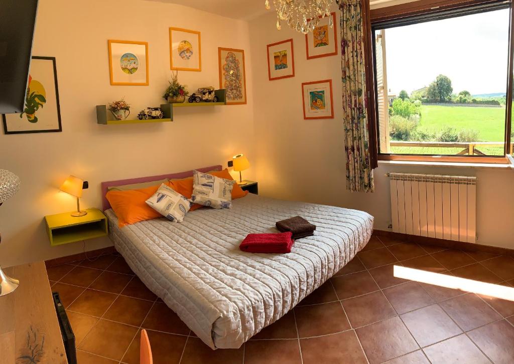1 dormitorio con cama con almohadas y ventana en Casa Paola nel Chianti, en Castelnuovo Berardenga