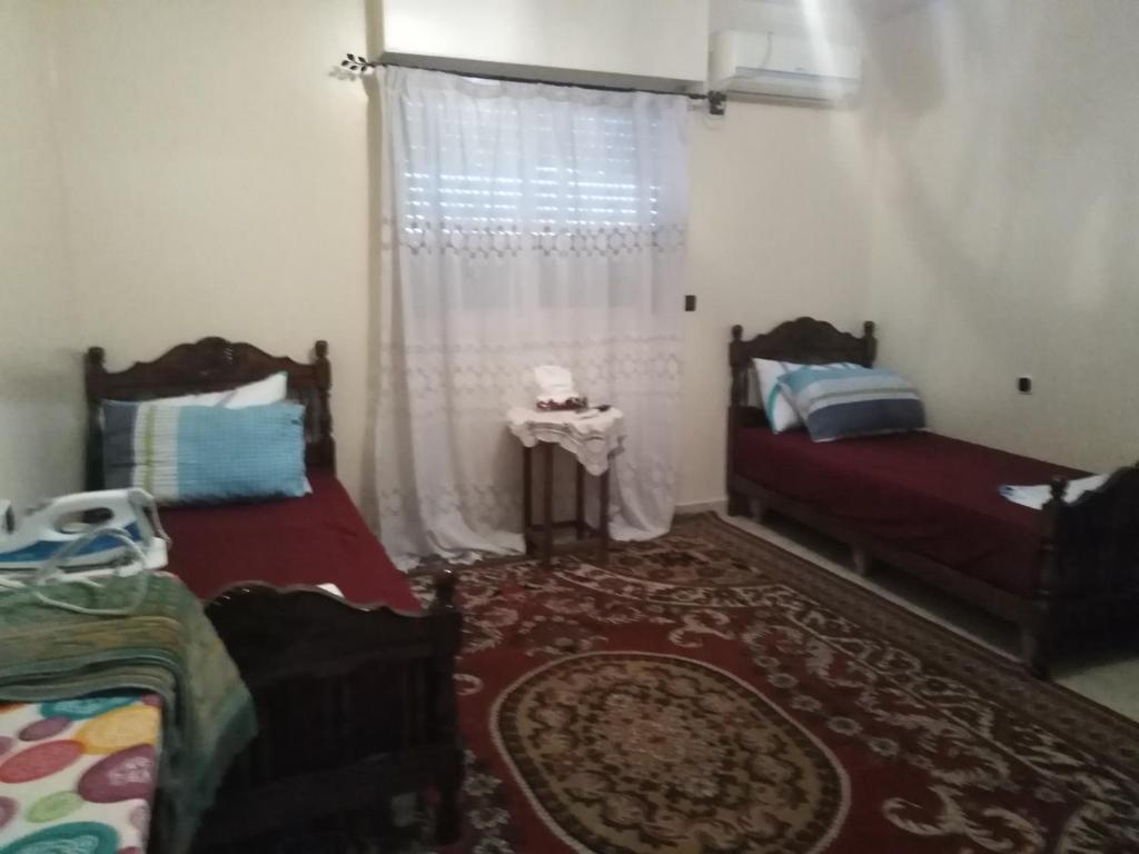 een slaapkamer met 2 bedden en een raam bij Appartement au centre Agadir résidence privée in Agadir