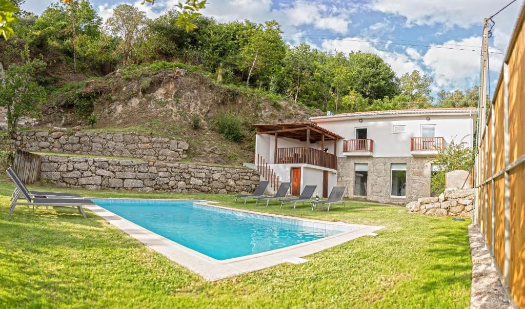 a villa with a swimming pool and a house at Casa da Pontelha in Terras de Bouro