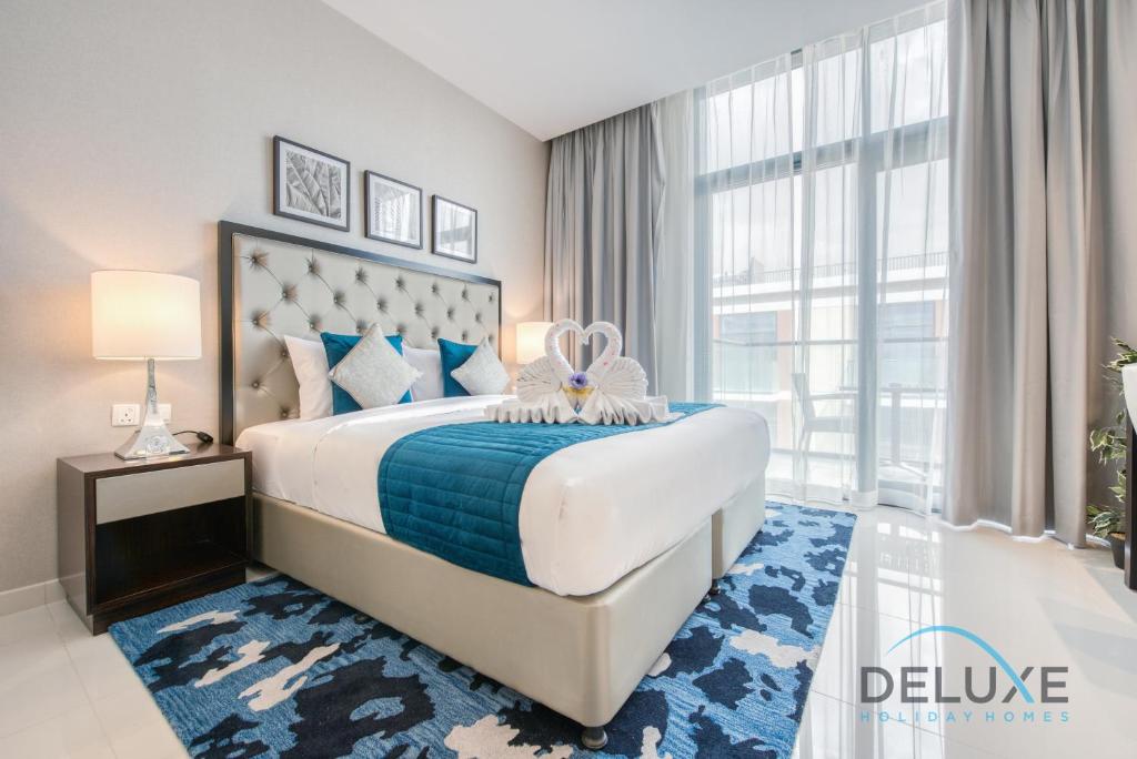 a bedroom with a large bed and a large window at Calm Studio in Damac Celestia A Dubai South by Deluxe Holiday Homes in Dubai