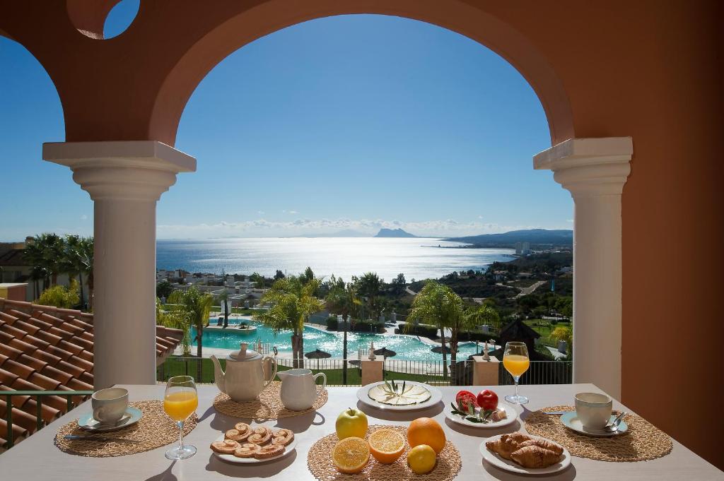 una mesa con comida y vistas al agua en Pierre & Vacances Resort Terrazas Costa del Sol en Manilva