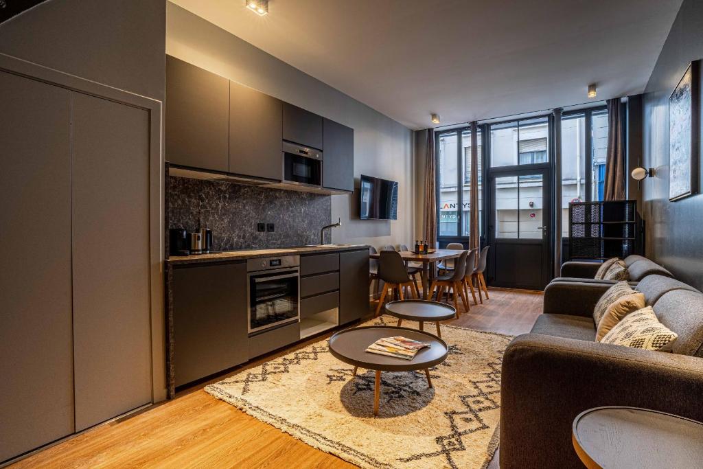 une cuisine et un salon avec un canapé et une table dans l'établissement 136 - Urban Beaumarchais Voltaire, à Paris