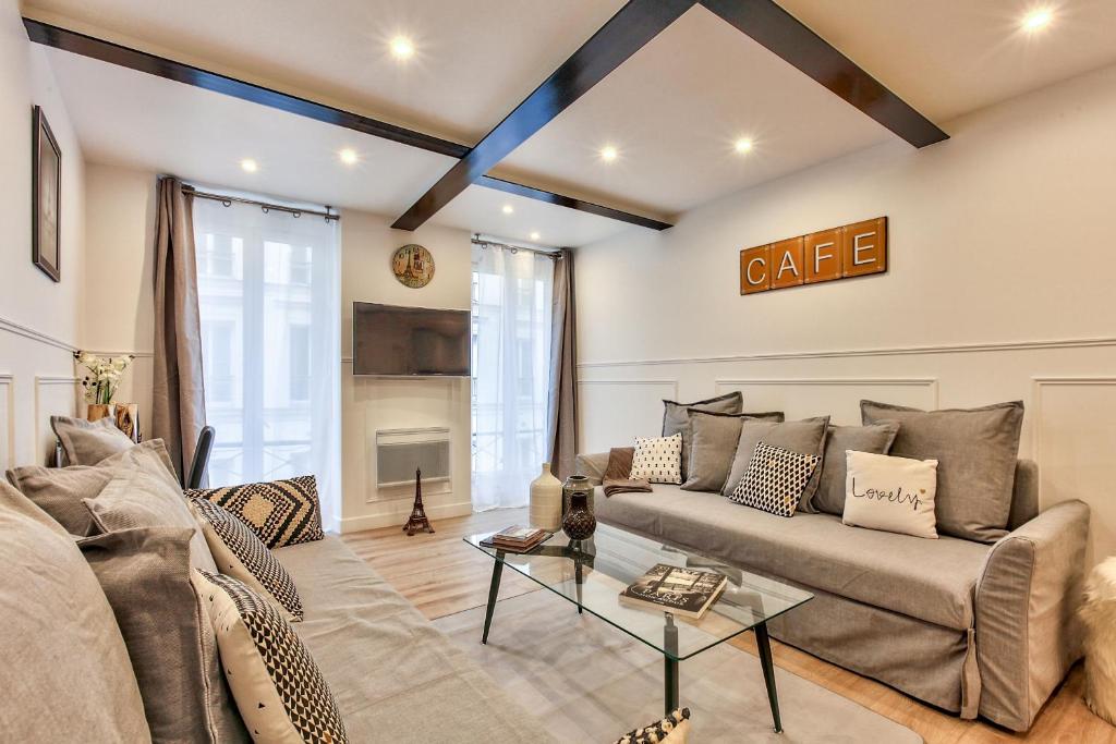 uma sala de estar com um sofá e uma mesa em 14 Luxury Flat Eiffel Design 1 em Paris