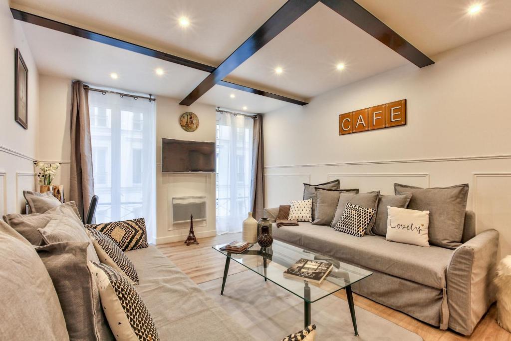 a living room with a couch and a table at 14 Luxury Flat Eiffel Design 1 in Paris