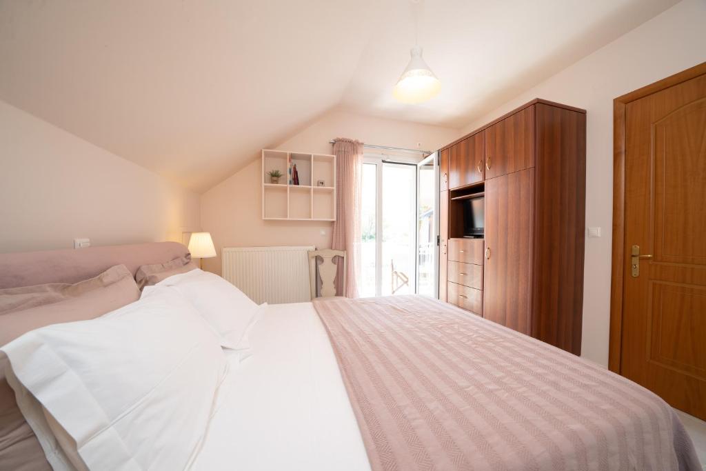 sypialnia z białym łóżkiem i drewnianą szafką w obiekcie Christina's place w mieście Sami