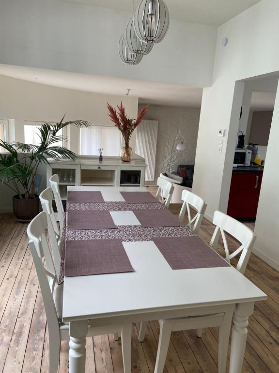 tavolo da pranzo bianco con sedie bianche e cucina di Casa Villa Borghese a Ostenda