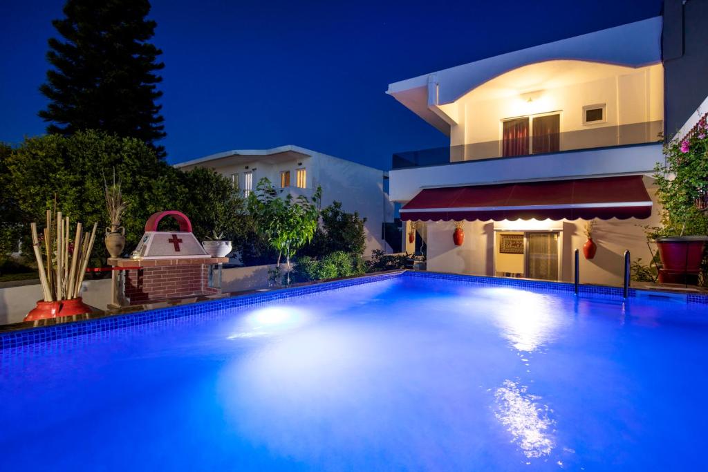 a swimming pool in front of a house at night at Margarita luxury apartment 1 in Faliraki