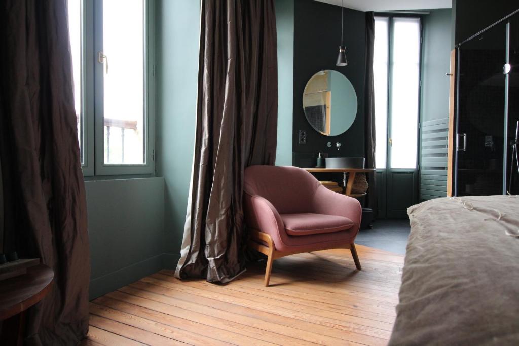 a bedroom with a chair and a mirror and a bed at B&B L'Escapade Bordelaise - Côté Jardin in Bordeaux