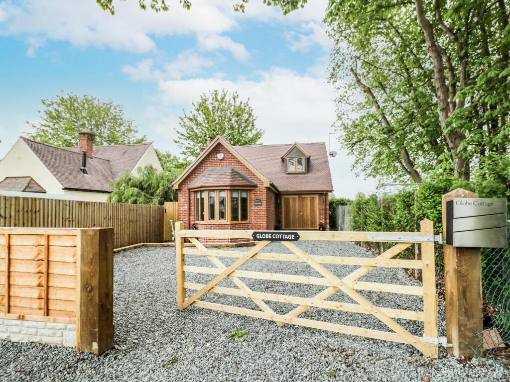 a wooden gate in front of a house at Globe Cottage in Stratford-upon-Avon