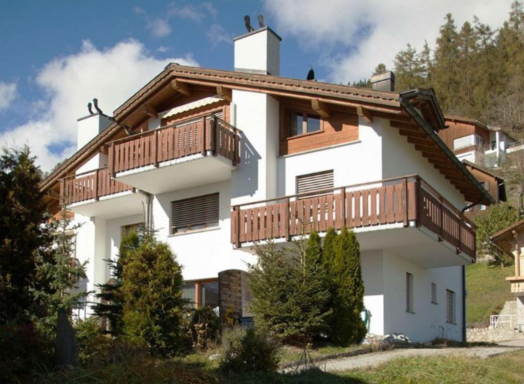 a large white building with wooden balconies on it at Renovated 3 Rooms Apartment in Ruschein near Laax in Ruschein