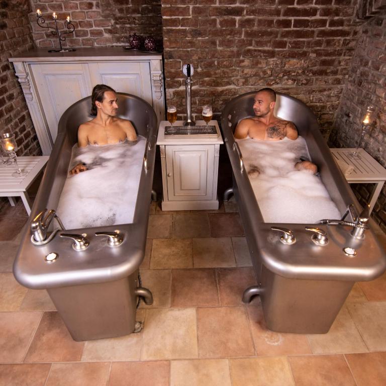 two men laying in bath tubs in a room at Hotel U Kata in Kutná Hora