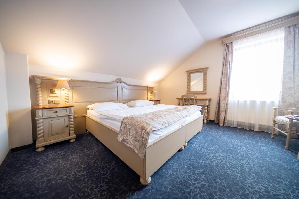 um quarto com uma cama grande e uma janela em Hotel U Kata em Kutná Hora