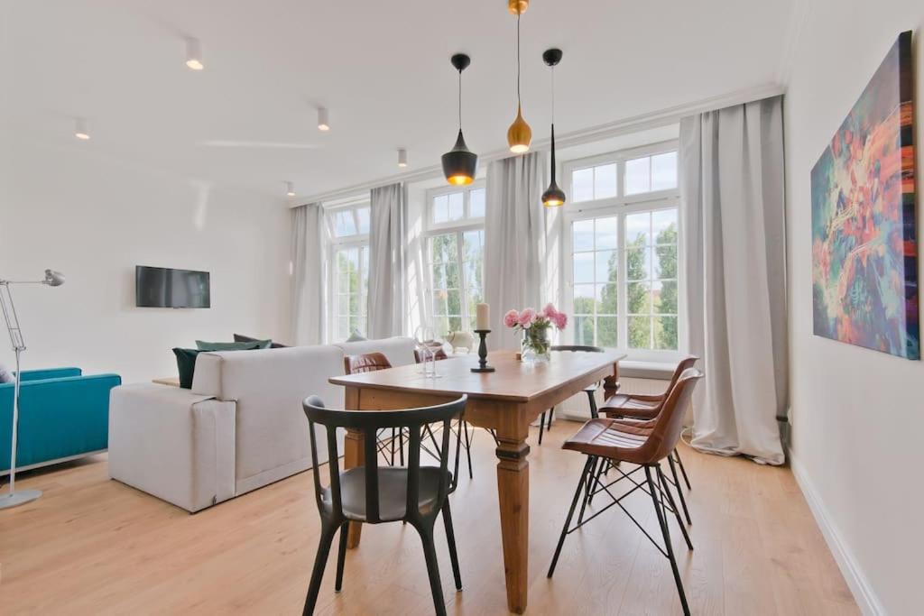 a dining room and living room with a table and chairs at Central Apartments Ogarna 3 in Gdańsk