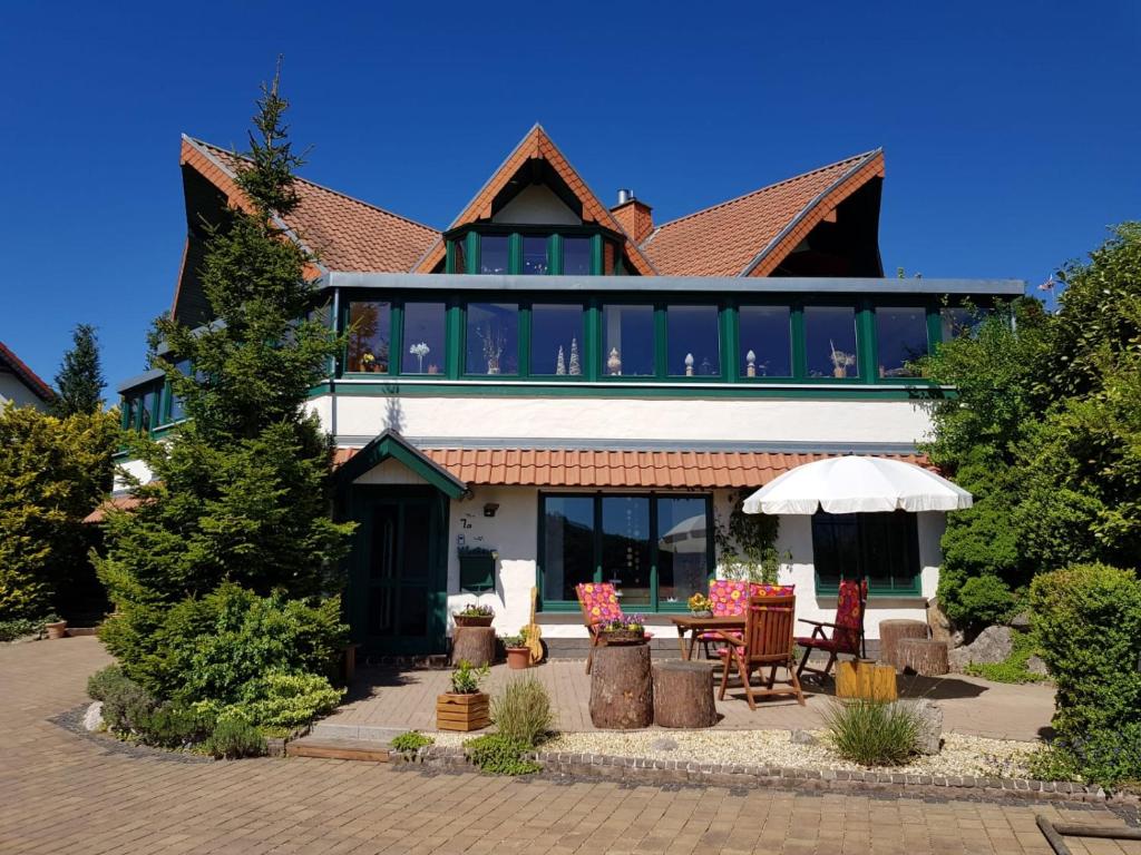 a large house with a patio with a table and chairs at Eure Auszeit in Vöhl