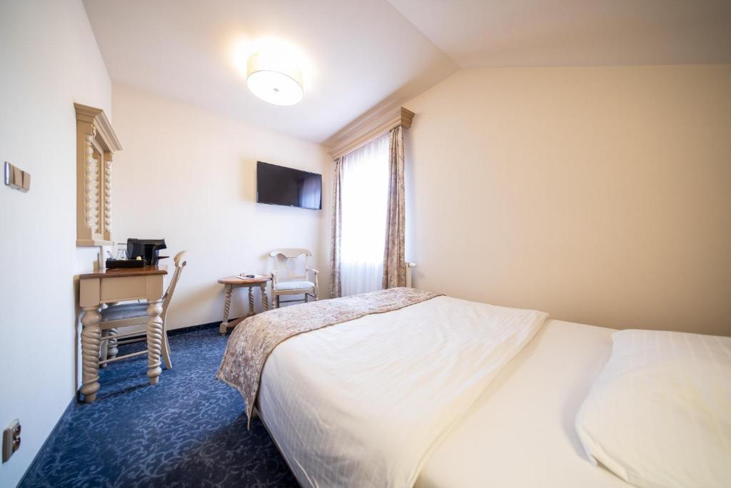 a hotel room with a bed and a window at Hotel U Kata in Kutná Hora