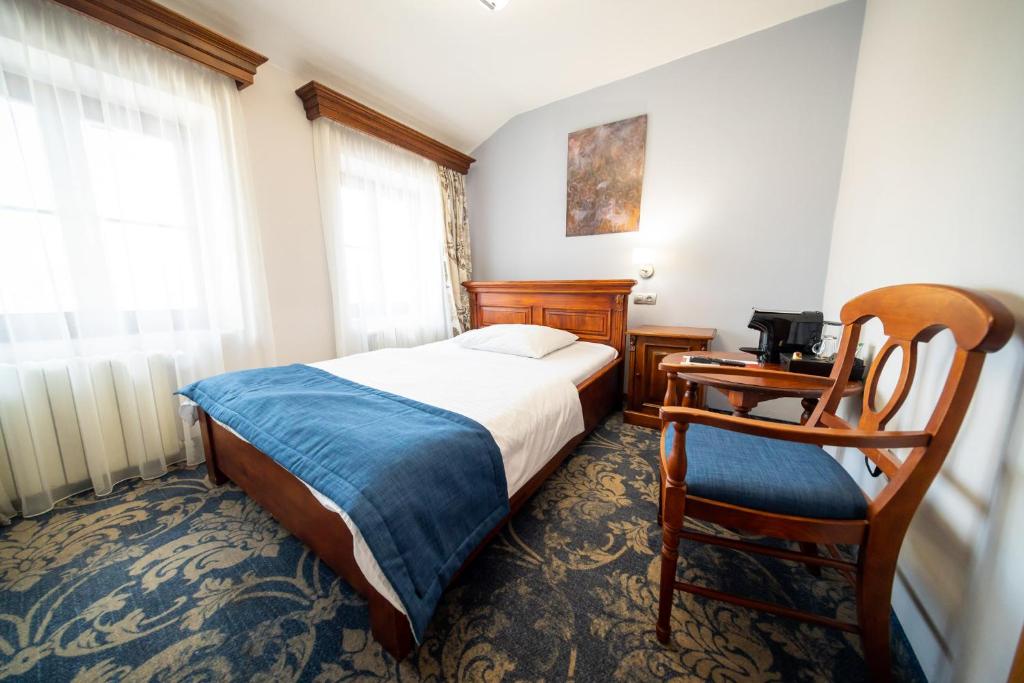 a bedroom with a bed and a desk and a chair at Hotel U Kata in Kutná Hora