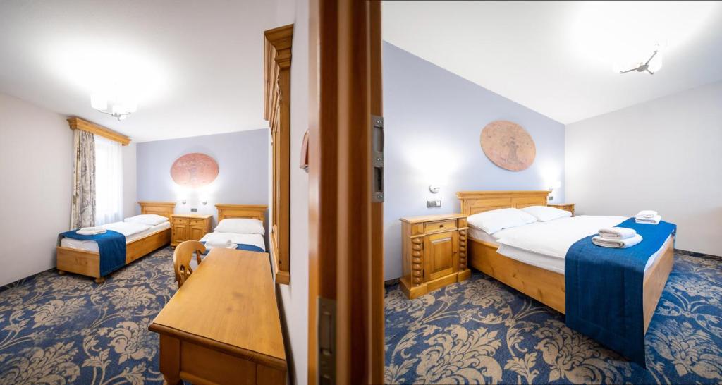 a hotel room with two beds and a desk at Hotel U Kata in Kutná Hora