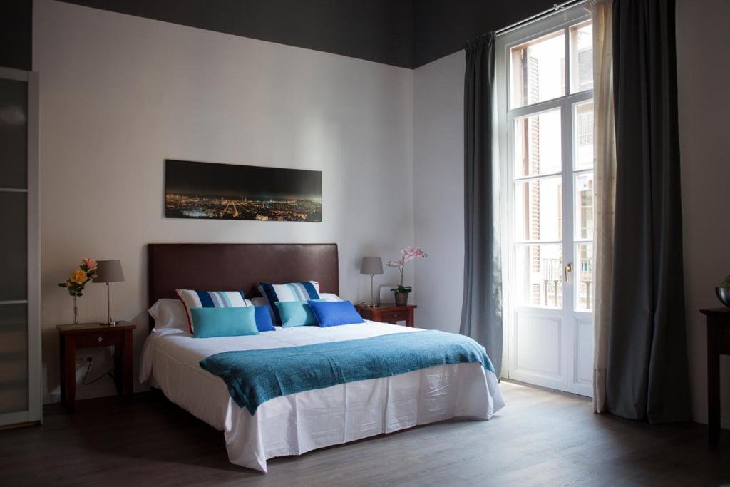 - une chambre avec un grand lit et des oreillers bleus dans l'établissement Colom Apartments, à Barcelone