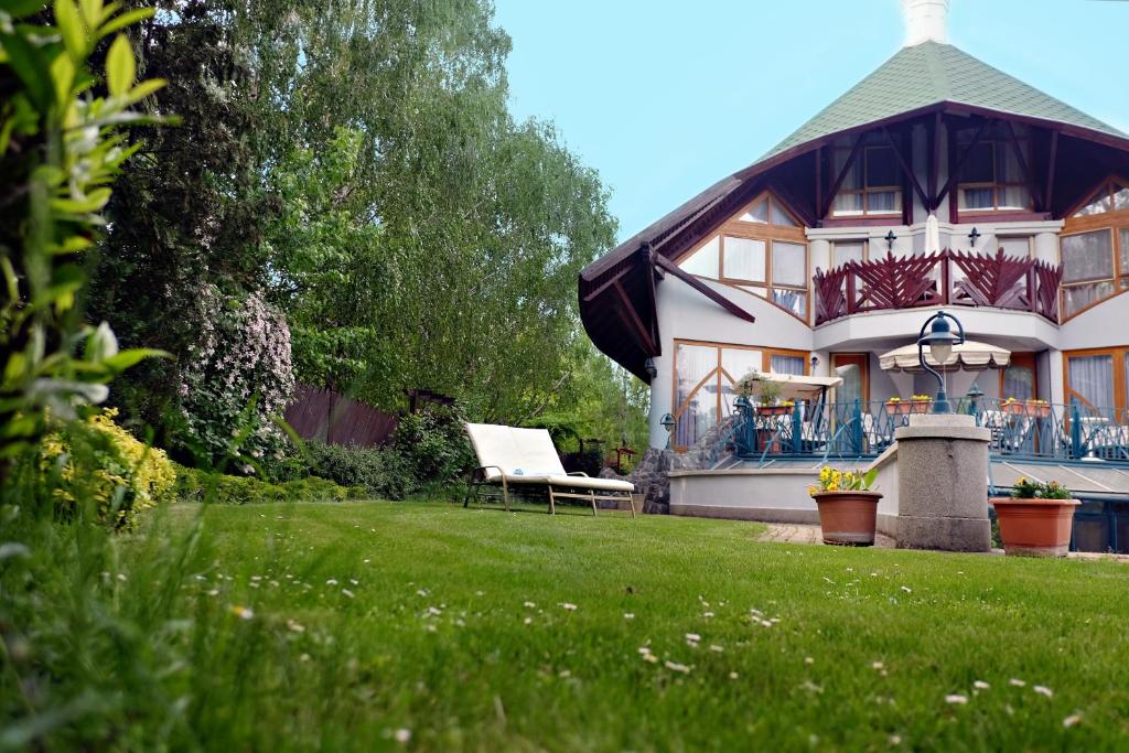 une maison avec une pelouse devant elle dans l'établissement Luxusvilla Balatonszárszó, à Balatonszárszó
