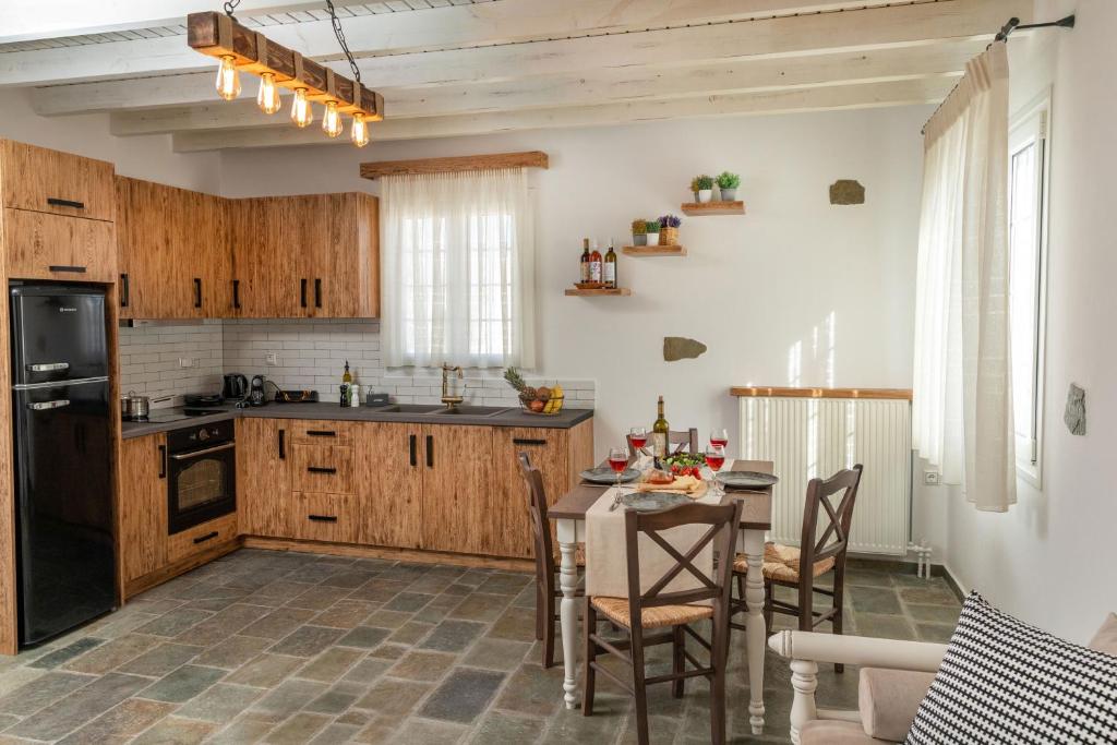 une cuisine avec des placards en bois et une table avec des chaises dans l'établissement Naxian Icon Luxury Residence, à Naxos Chora