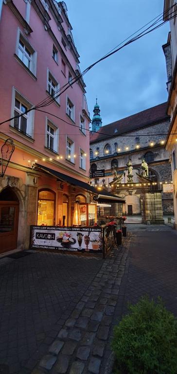 a large pink building next to a street at Willa przy Czarnej Bramie in Kłodzko