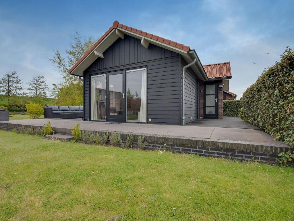 una pequeña casa con una gran ventana en el césped en Lovely Holiday Home in Kattendijke with Garden en Kattendijke