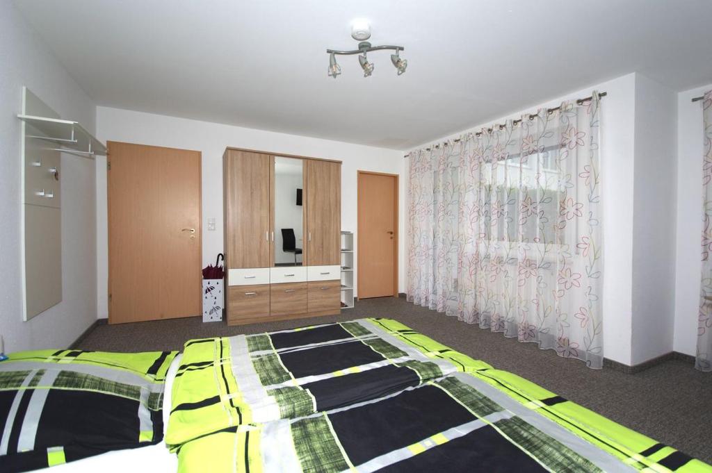 ein Schlafzimmer mit einem gelben und schwarzen Bett und einem Fenster in der Unterkunft Ferienwohnung in Kempten am Stadtweiher in Kempten