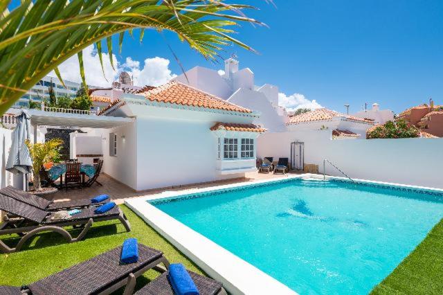 a villa with a swimming pool in front of a house at Casa Virgo in Adeje