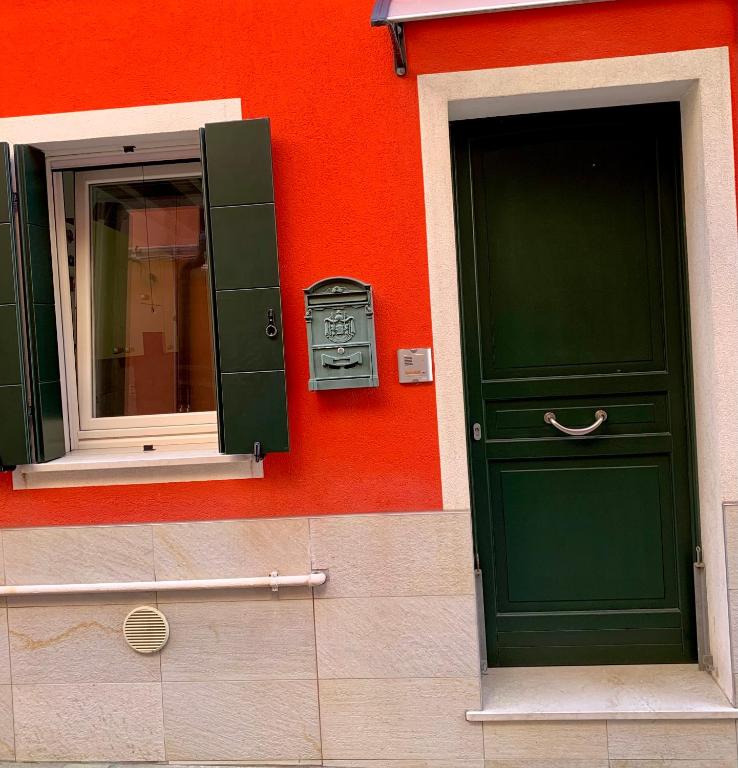 a building with a green door and a mirror at Casa Antico Barbiere in Chioggia
