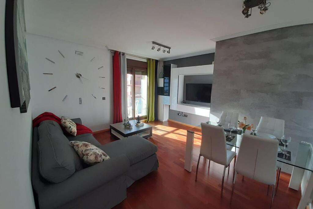 uma sala de estar com um sofá e um relógio na parede em Piso céntrico con piscina,parking y jacuzzi em Córdoba