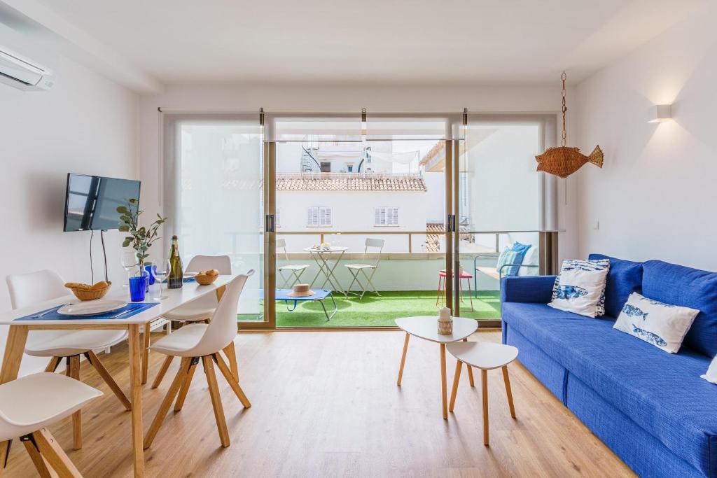 - un salon avec un canapé bleu et une table dans l'établissement Balaixa 8, à Port de Pollença