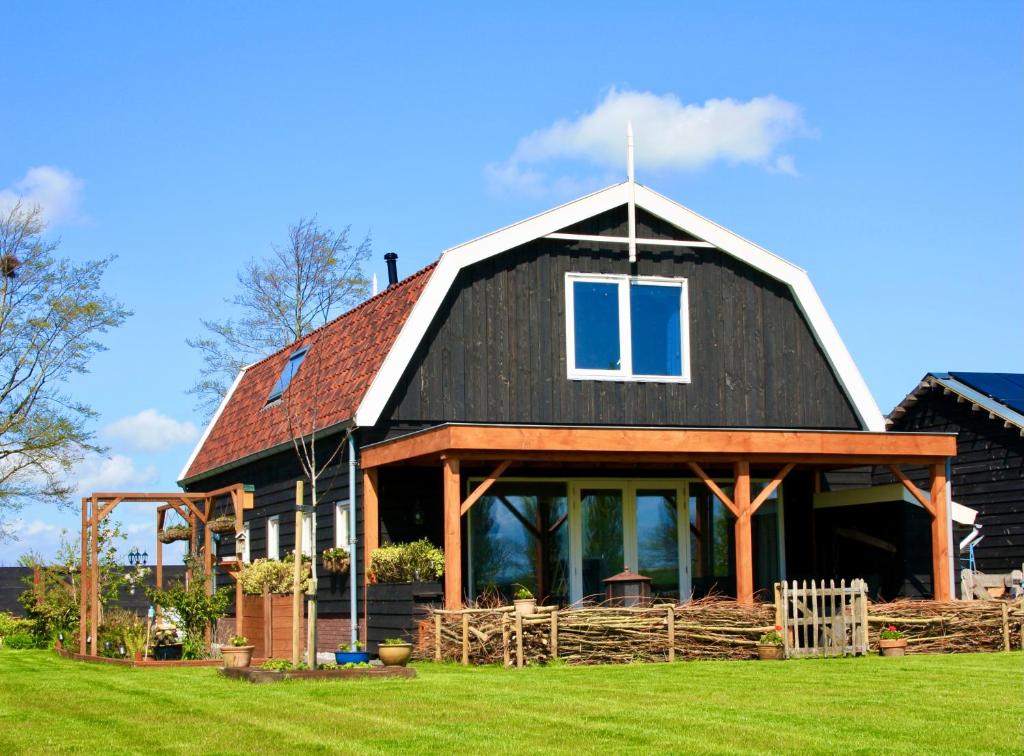 a large black barn with a gambrel roof at De Heerlijkheid Hensbroek in Hensbroek