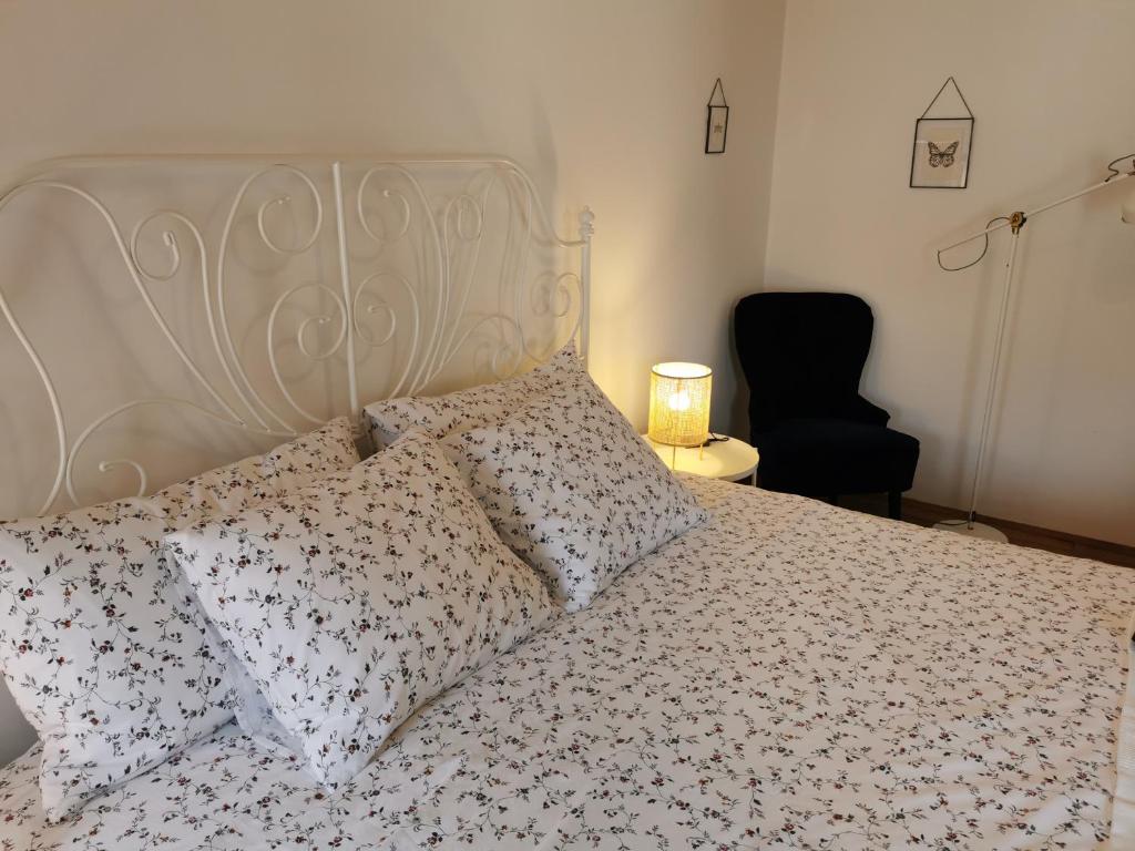 a bedroom with a white bed with pillows and a chair at Salvia in Pićan