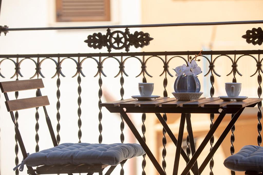 una mesa con dos sillas y un jarrón azul. en Appartamenti Marinero, en Castellammare del Golfo