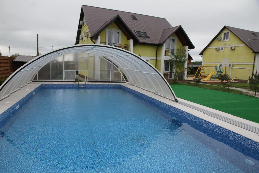 ein Schwimmbad mit einer Metallbrücke über ein Haus in der Unterkunft Боброва-Хата in Switjas