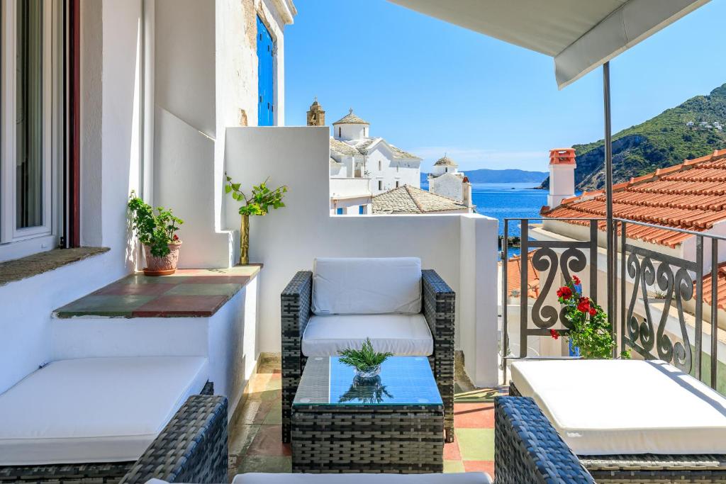 a balcony with chairs and a view of the ocean at Thimisi in Skopelos Town