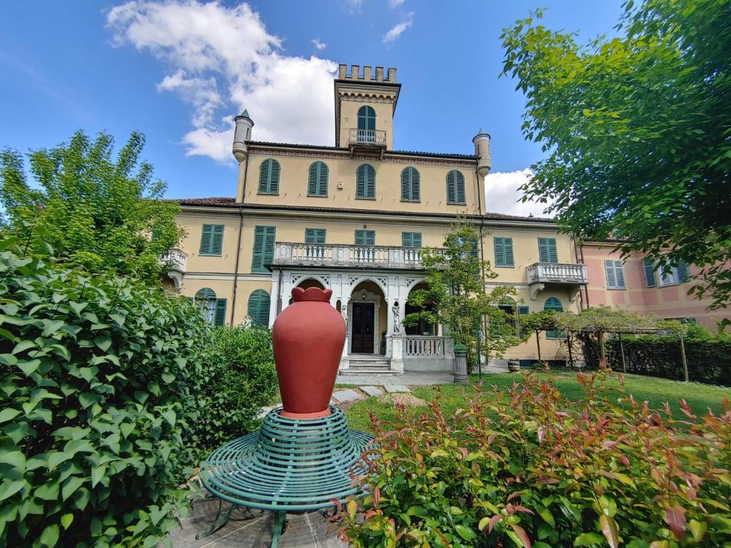 a red vase sitting in front of a building at B&B Villa Ferrari in Asti