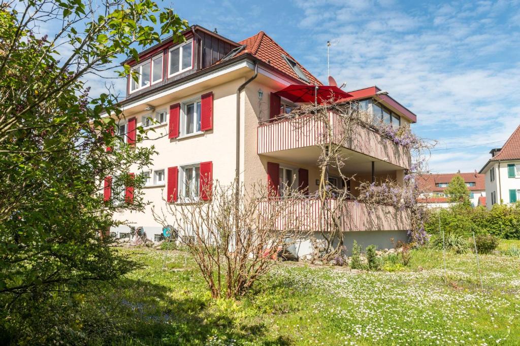 a house with red shutters on the side of it at Flair Ferienwohnung Lilie in Stockach