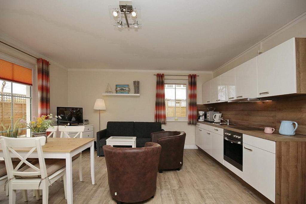 a kitchen and living room with a table and chairs at Strandvilla Krabbe Wohnung 08 in Boltenhagen