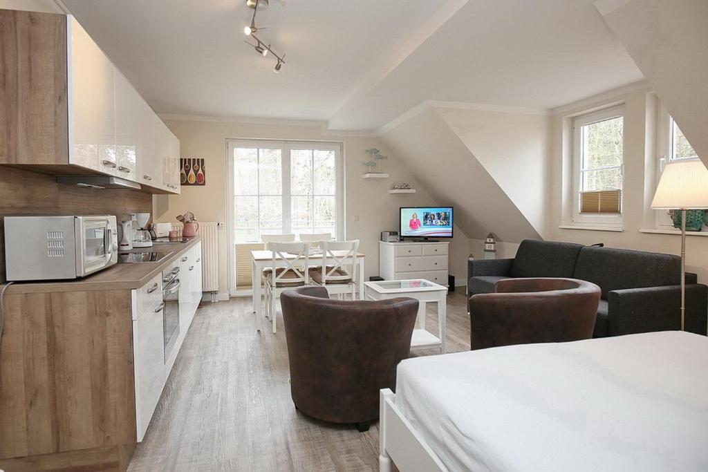 a kitchen and living room with a table and chairs at Strandvilla Krabbe Wohnung 12 in Boltenhagen