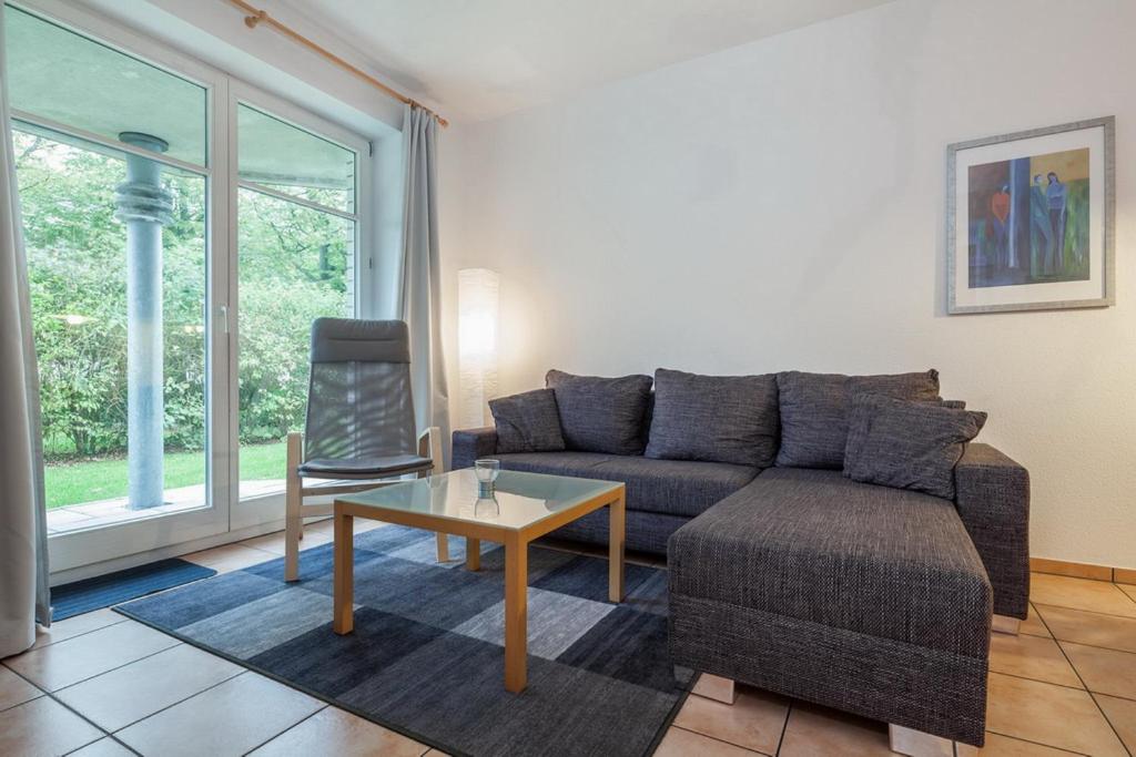 - un salon avec un canapé et une table dans l'établissement Dünenblick Wohnung 19, à Boltenhagen