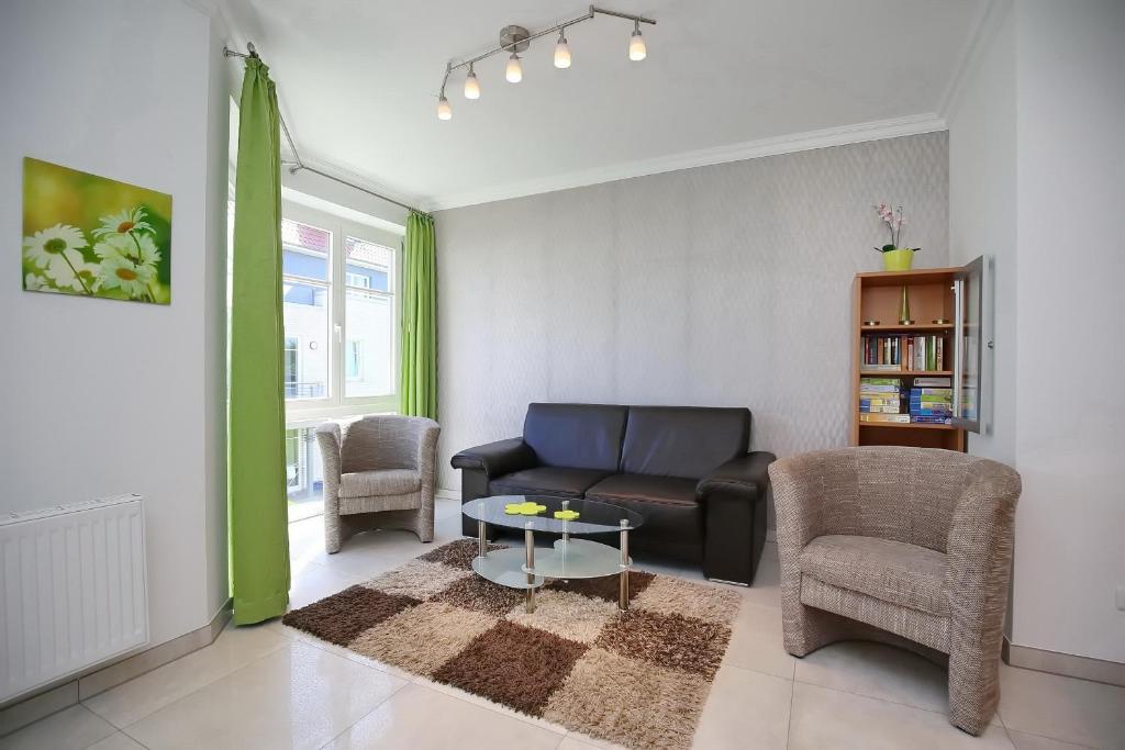 a living room with a couch and a table and chairs at Dünenblick Wohnung 27 in Boltenhagen