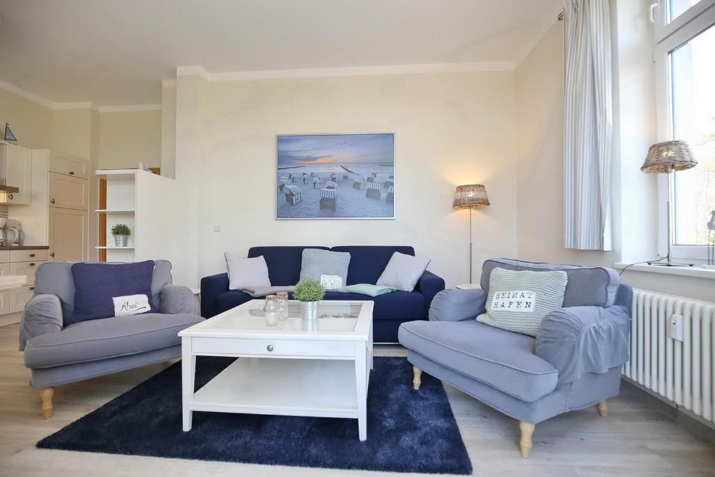 a living room with two blue couches and a table at Villa Triton Wohnung 01 in Boltenhagen