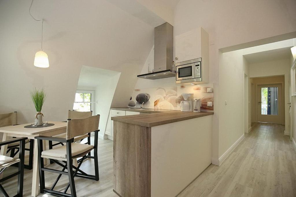 a kitchen and dining room with a table and chairs at Strandvilla Scholle - Aal Wohnung 06 in Boltenhagen