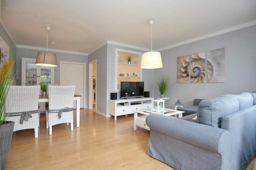 Il comprend un salon doté d'un canapé et d'une table avec une télévision. dans l'établissement Sünnslag Wohnung 096, à Boltenhagen