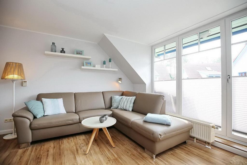 ein Wohnzimmer mit einem Sofa und einem Tisch in der Unterkunft Papillon Wohnung 10-6 in Boltenhagen