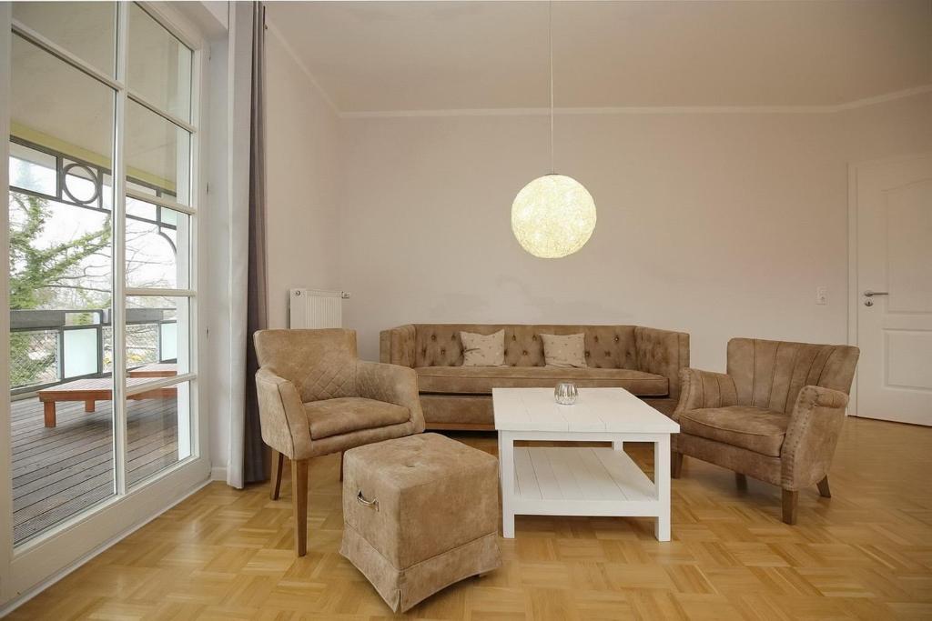 a living room with a couch and two chairs and a table at Likedeeler II Wohnung 04 in Boltenhagen