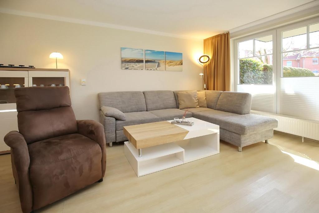 a living room with a couch and a chair and a table at Papillon Wohnung 15-2 in Boltenhagen