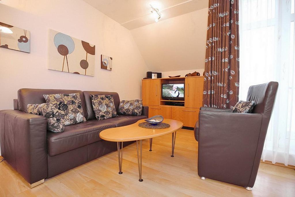 a living room with a couch and a table and a tv at Haffblick Wohnung 11 in Boltenhagen